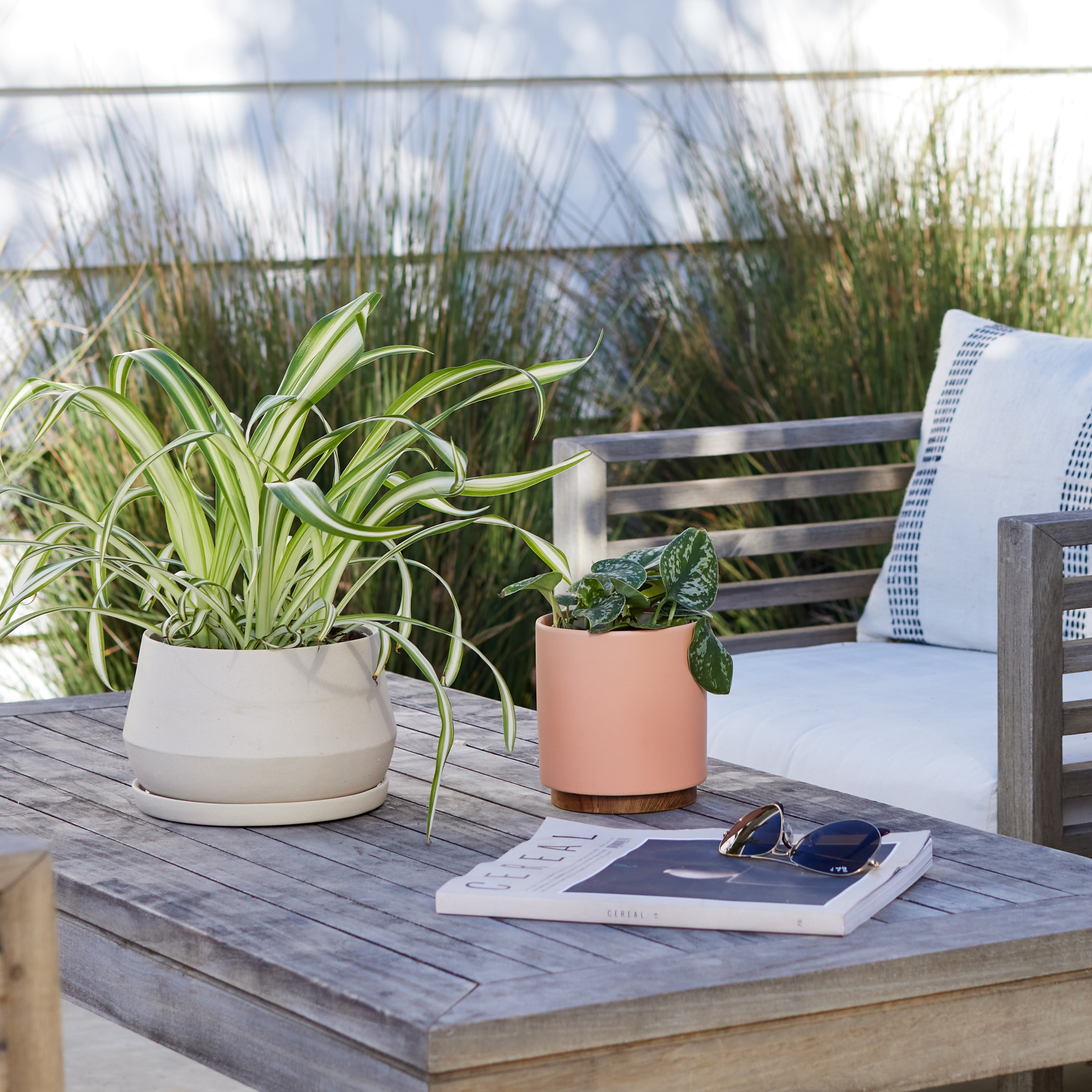 Lifestyle photo of a sand Rancho Planter on a wooden outdoor patio table.