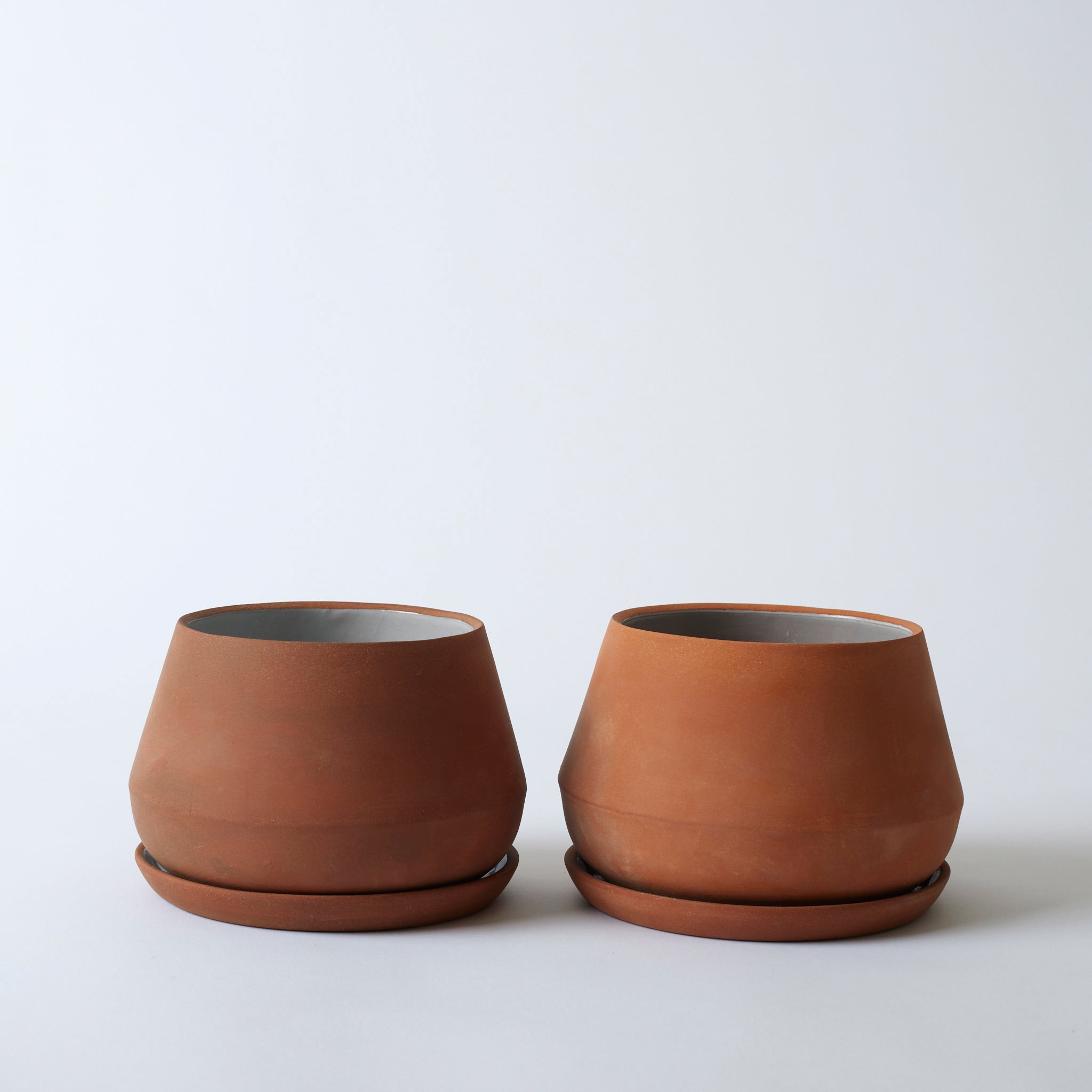 Image of two 7" terra cotta Rancho Planters next to each other. You can see the variation in each. One is slightly darker than the other - a natural handmade process.