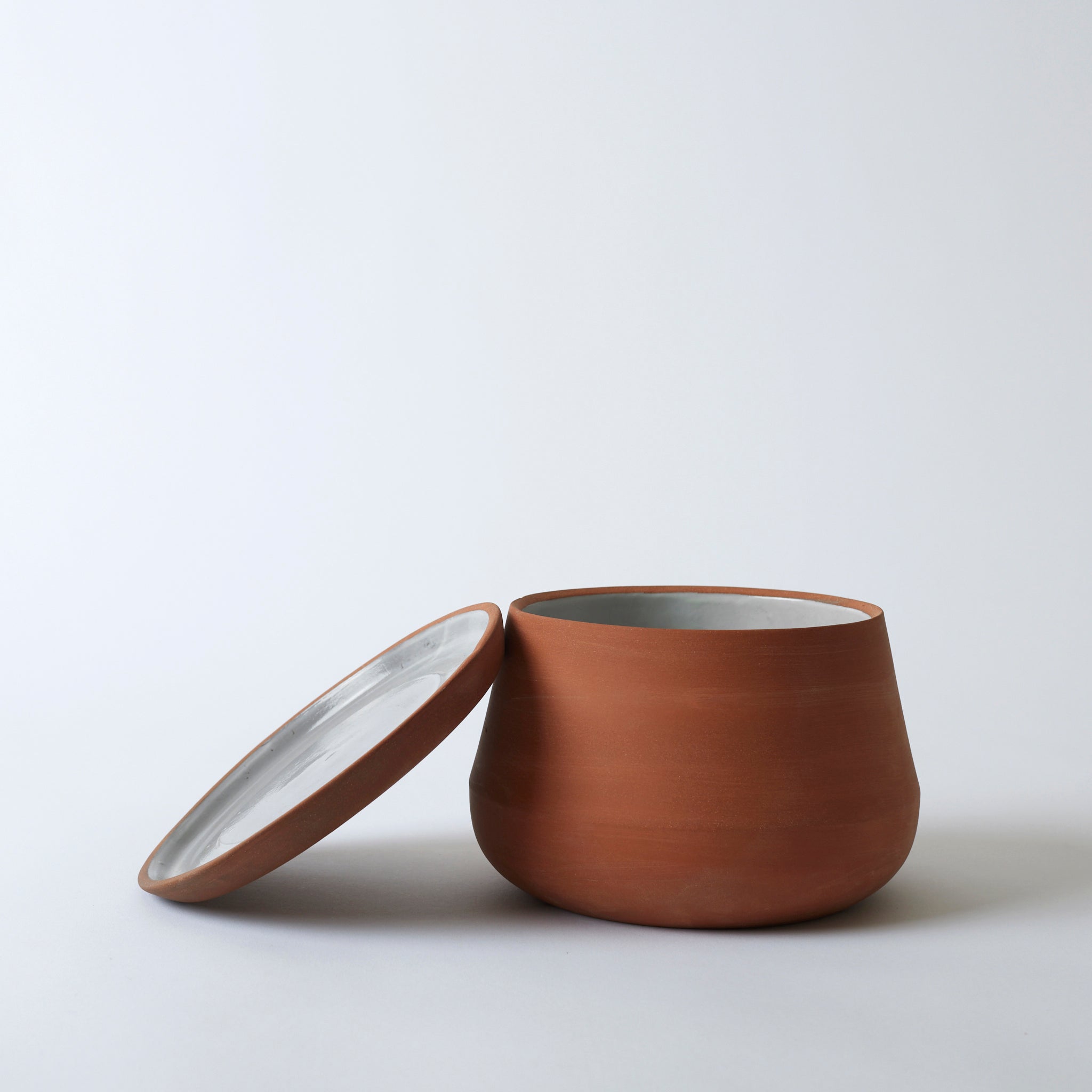 Silo image of the terra cotta Rancho Planter with its tray propped up on the pot.