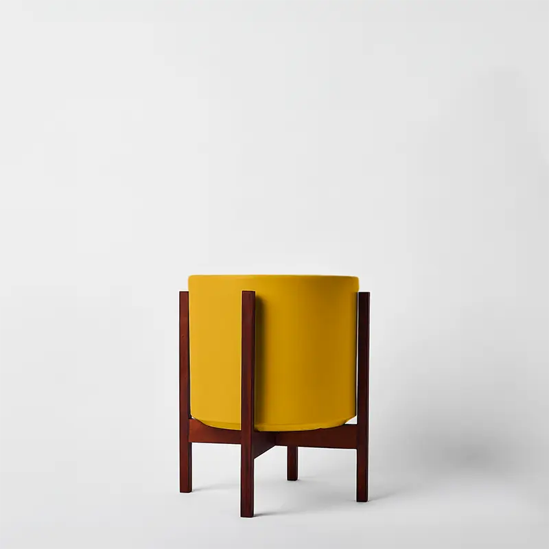 Mustard 10 Inch plant planter with dark square stand on a white background