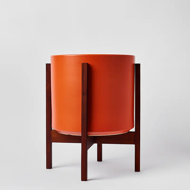 Rust 12 Inch planter with dark square stand on a light gray background