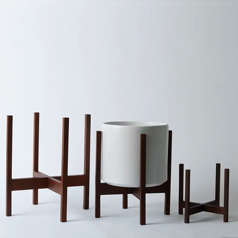 White planter with dark wooden stands on a light gray background