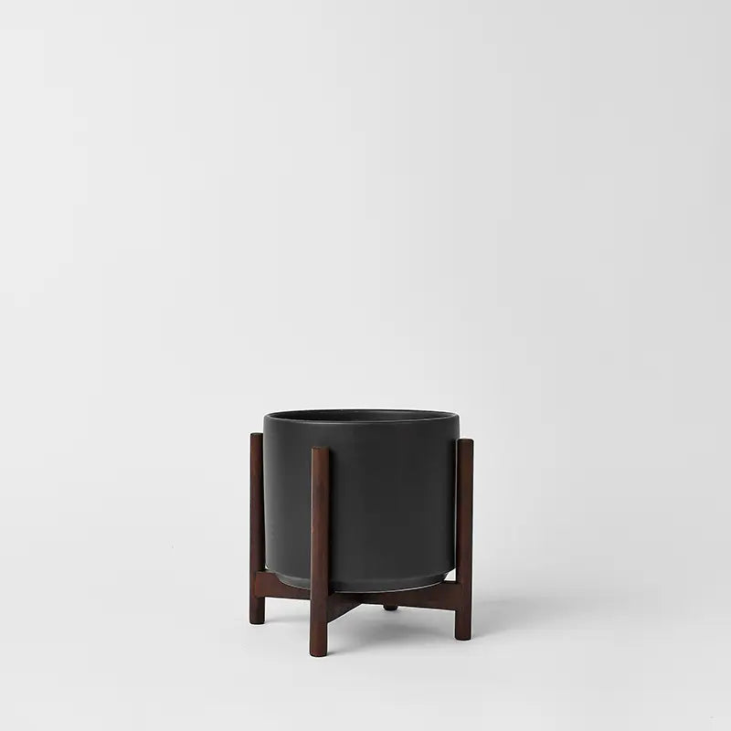 Black 6 Inch planter with dark rounded stand on a light gray background