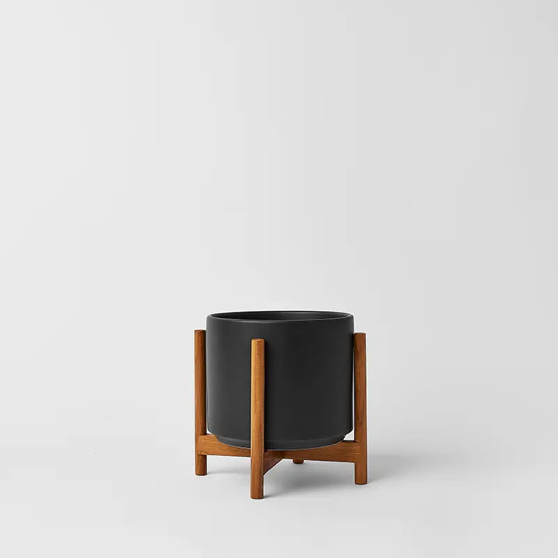 Black 6 Inch planter with light rounded stand on a natural gray background