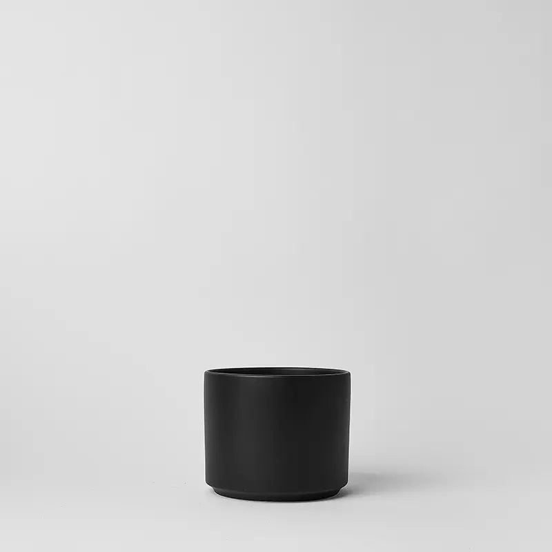 Black 6 inch cylindrical pot on a light gray background