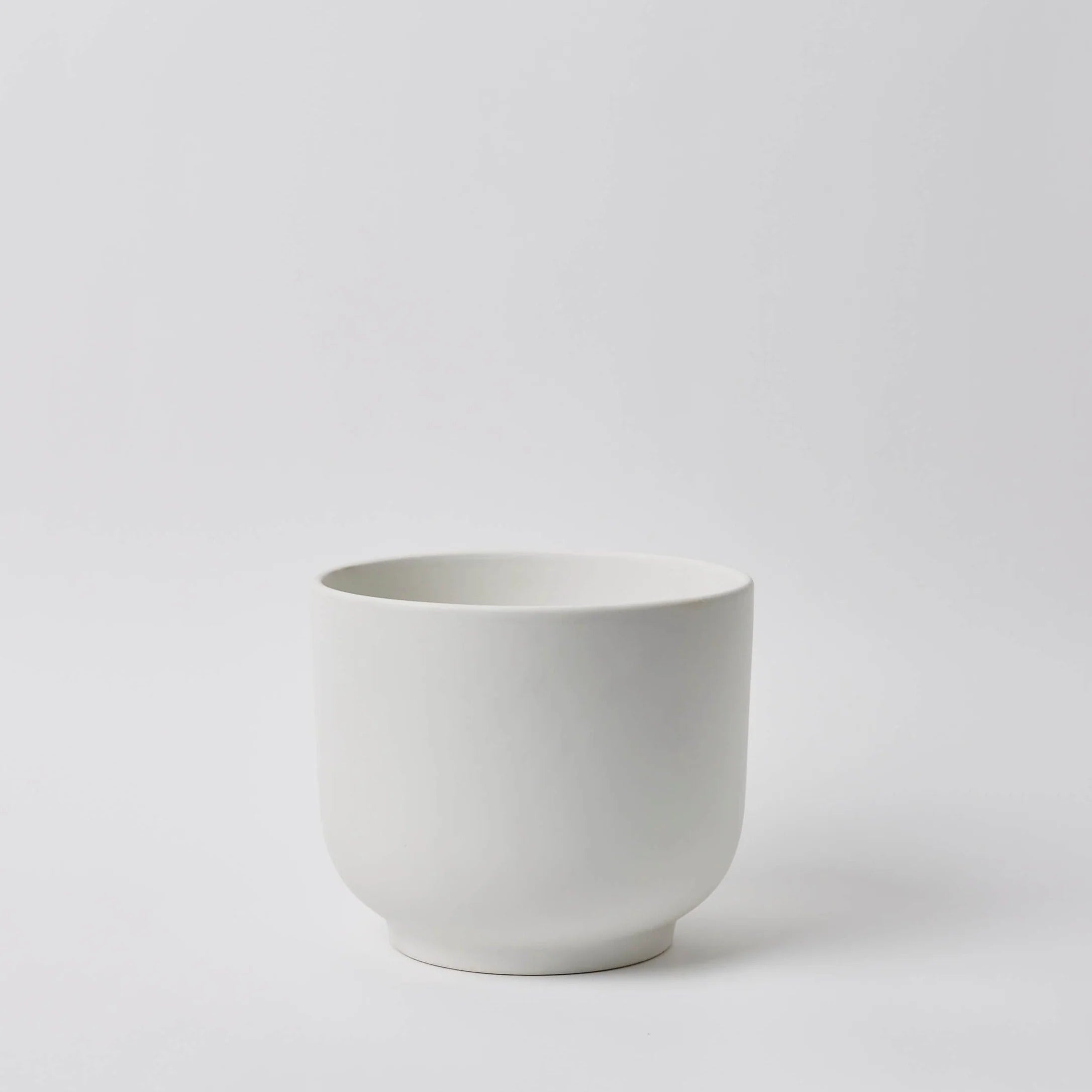 White ceramic planter on a light gray background