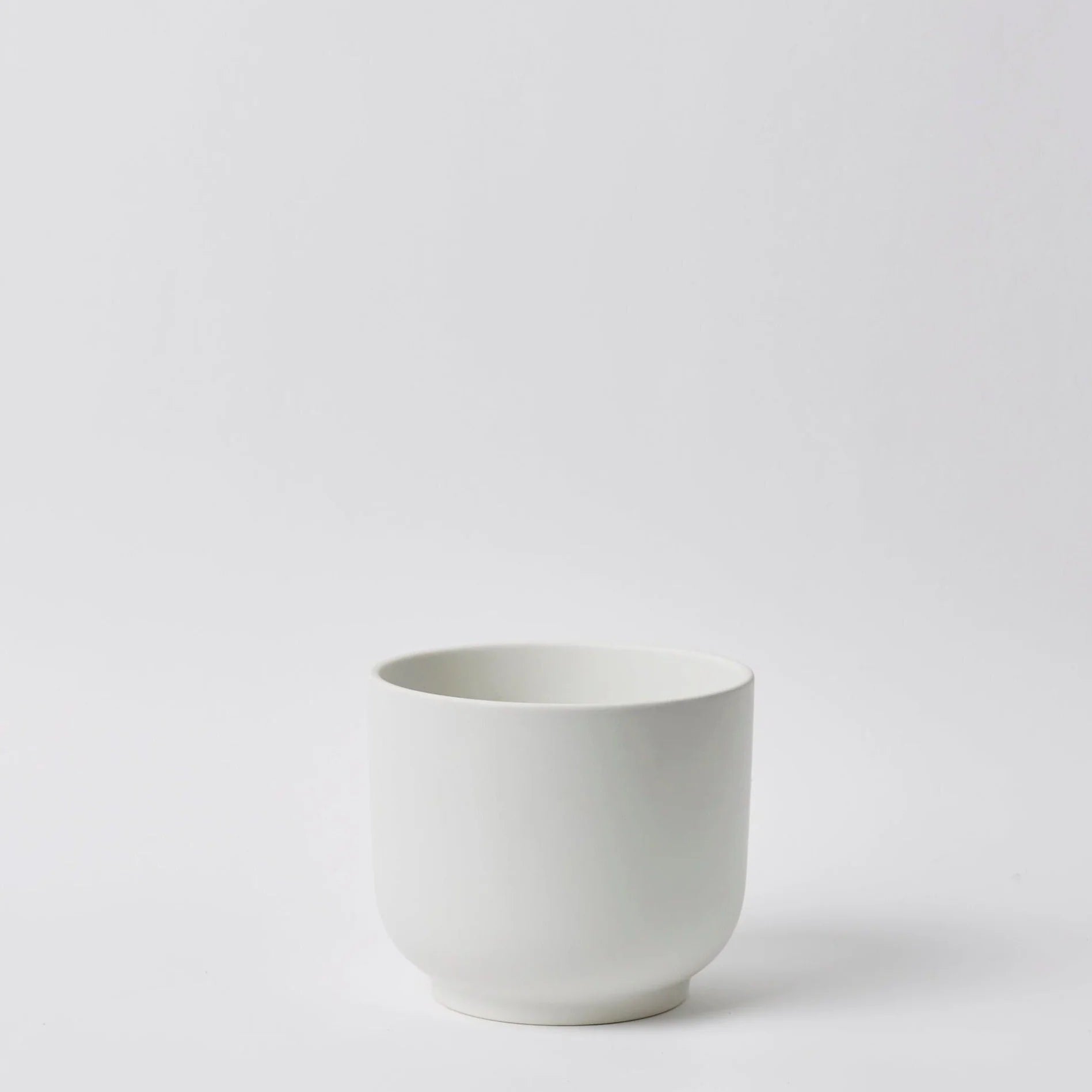 White ceramic planter on a light gray background