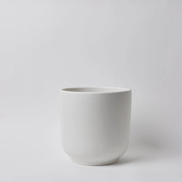 White ceramic planter on a light gray background