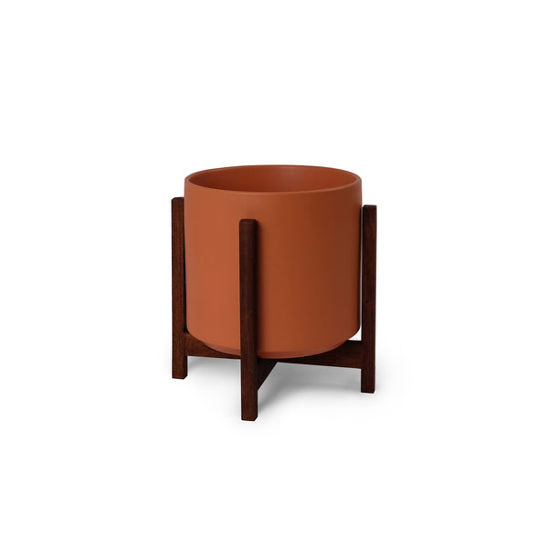 Ceramic planter with wooden stand on a white background