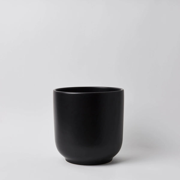 Black ceramic cup on a light gray background