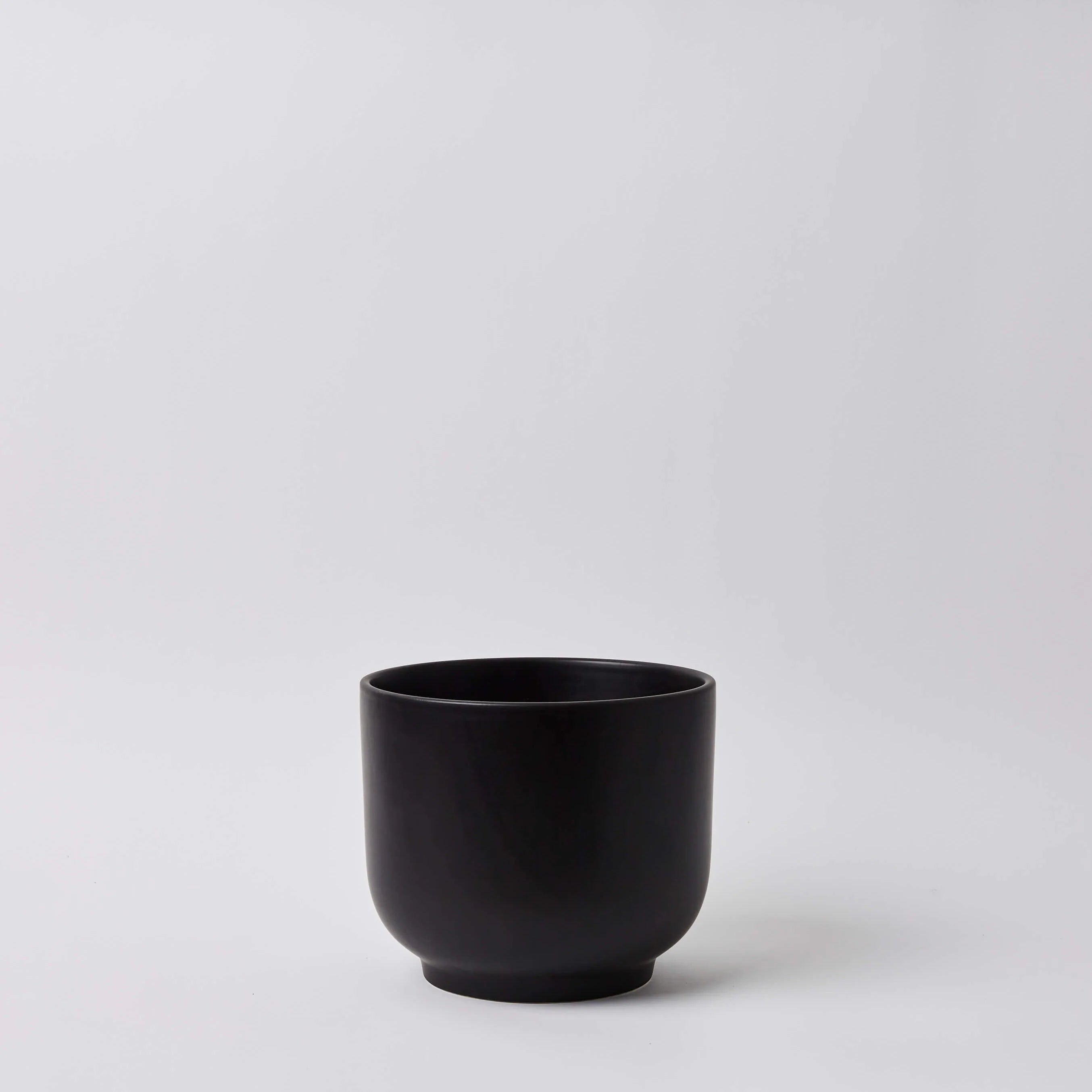 Black ceramic cup on a light gray background