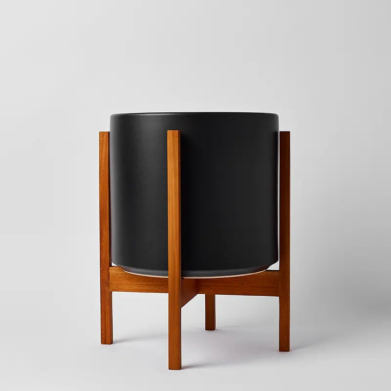 Black planter with light square stand on a gray background