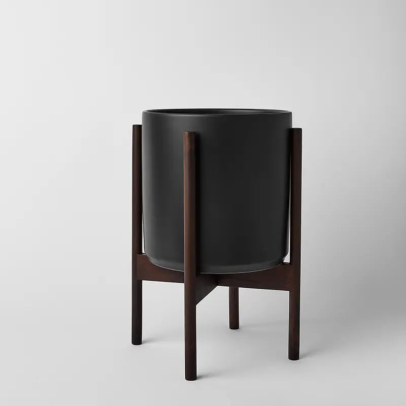 Black 10 Inch planter with dark rounded stand on a light gray background