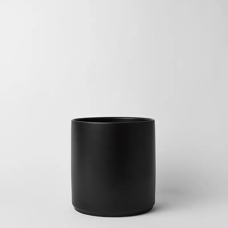Black 10 inch cylindrical pot on a light gray background