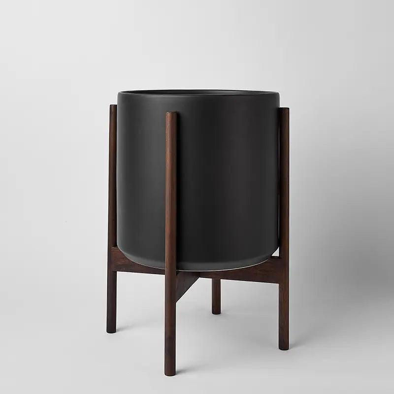 Black 12 Inch planter with dark rounded stand on a light gray background